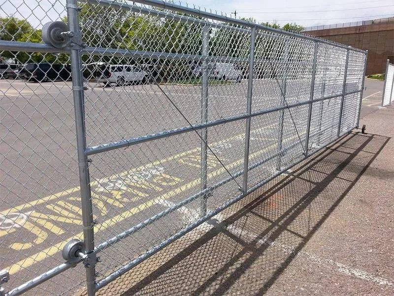 Galvanized chain link sliding gate across a paved commercial entrance