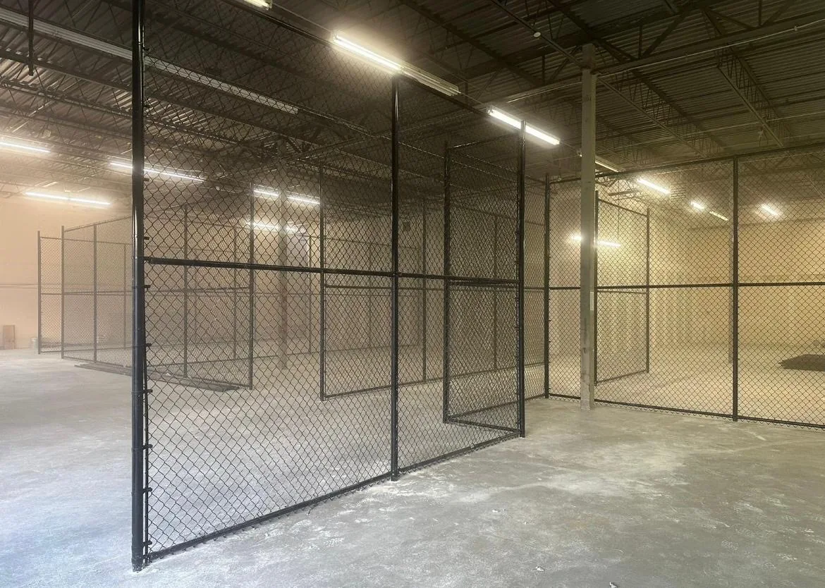 Black chain link partitions and gates inside a commercial building, installed by Eagle Fencing