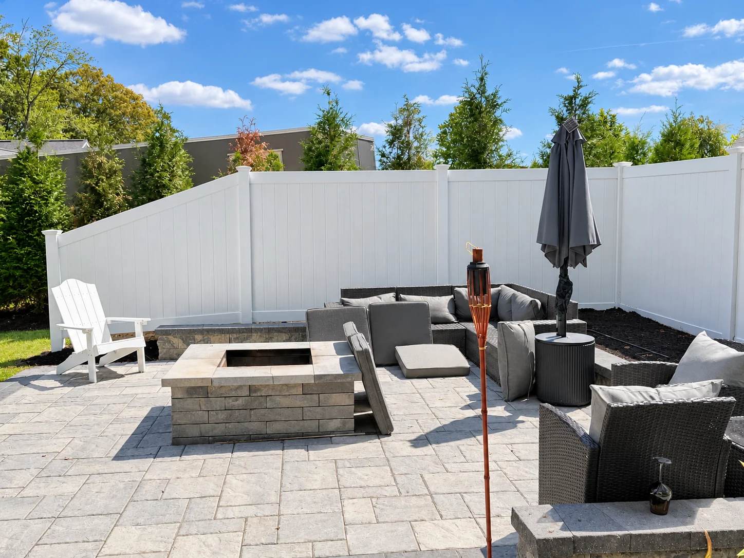 White vinyl privacy fence around a patio — residential fencing options for Salem and Southern NH