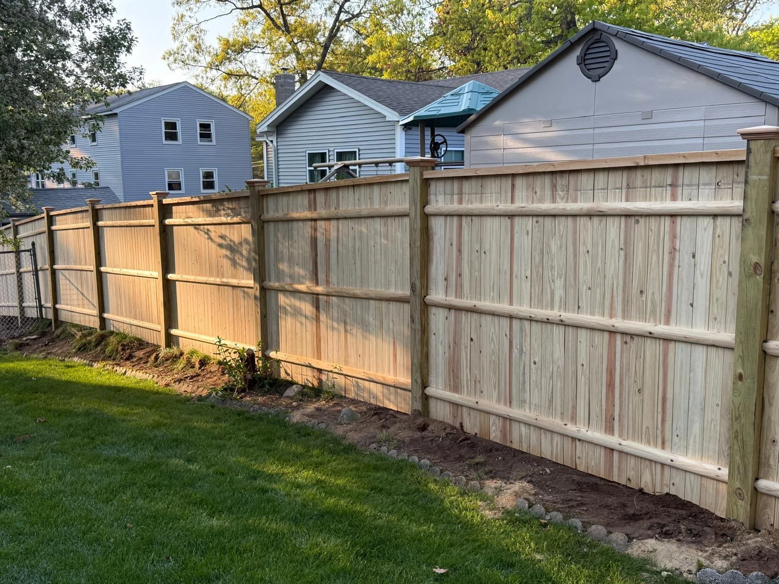 Wood privacy fence beside a backyard